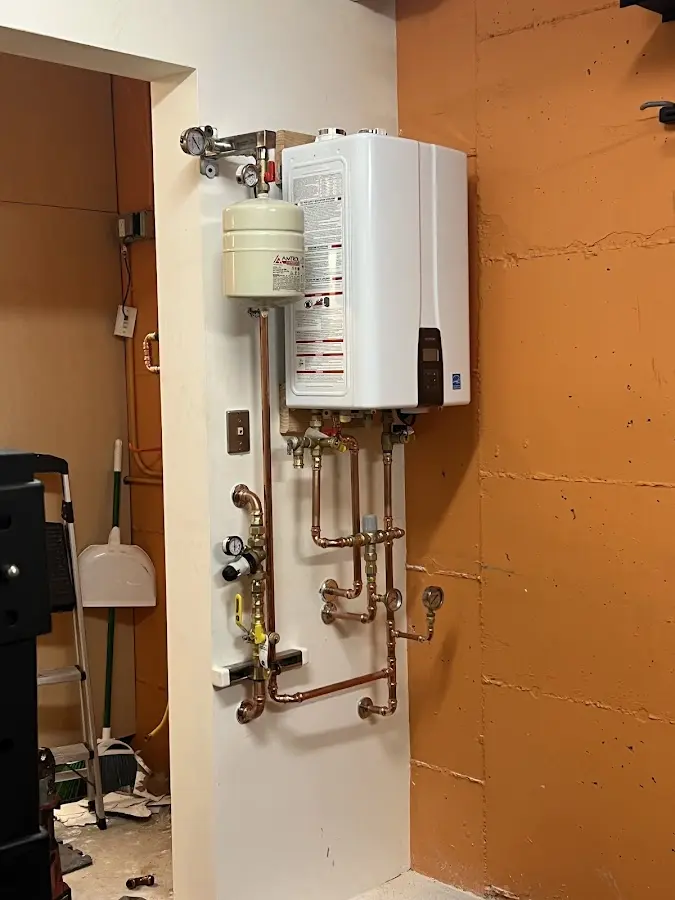 Plumbing technician inspecting water heater connections in Siler City